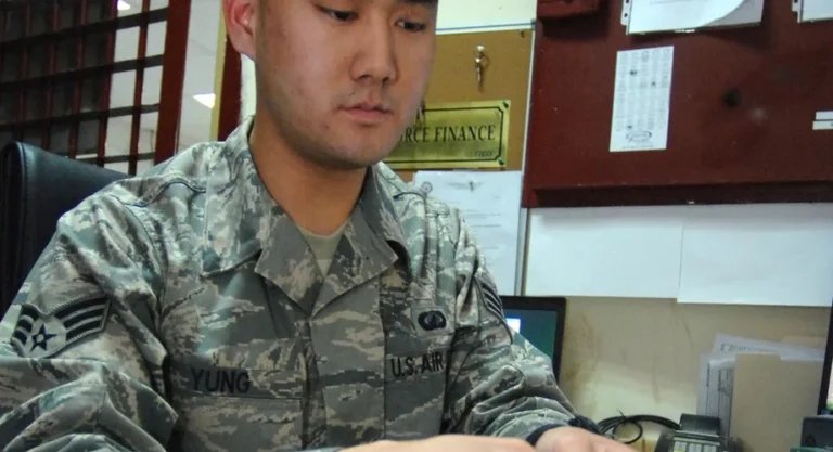 U.S. Air Force finance airman counting cash at a finance office