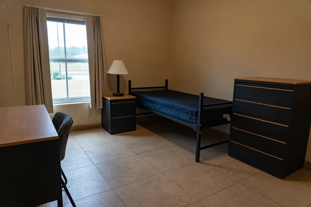 Newly furnished Army barracks room — single soldiers in barracks receive partial BAH only