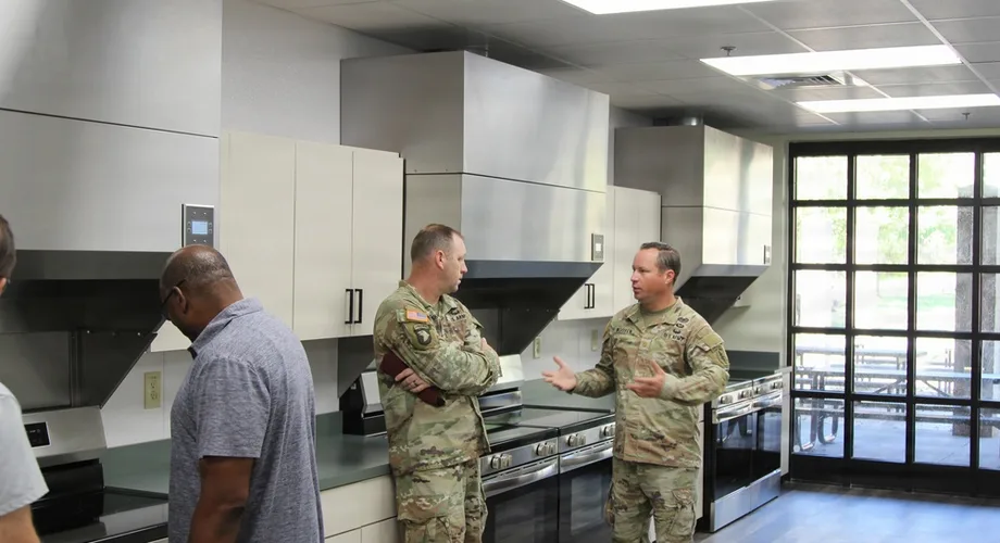 U.S. Army soldiers inspecting a newly installed community kitchen in a Fort Bragg barracks building.