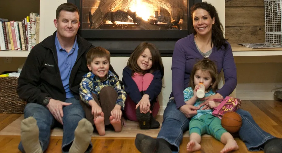 Military family of five sitting by their fireplace at home