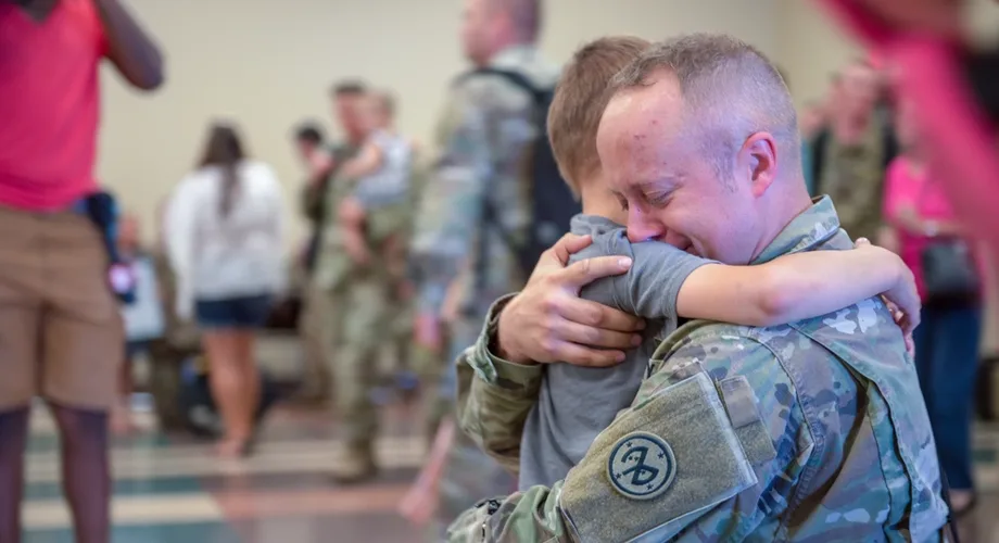 Soldier hugging his young son at a homecoming ceremony