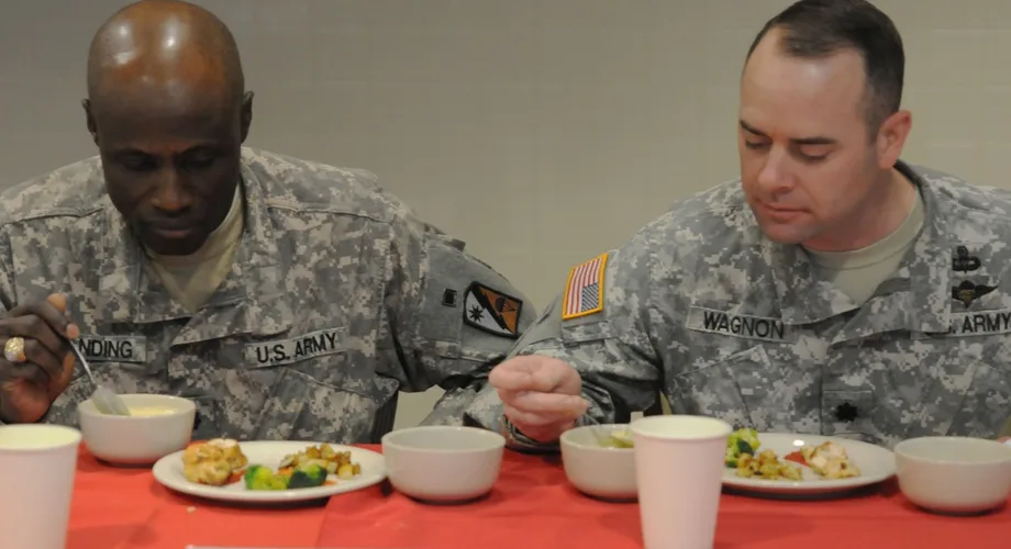 Two U.S. Army soldiers tasting food at a military dining facility event (U.S. Army photo by SSG Amanda Tucker, public domain)
