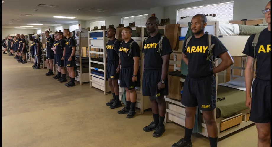 Army trainees standing beside barracks bunks at Fort Jackson during basic training